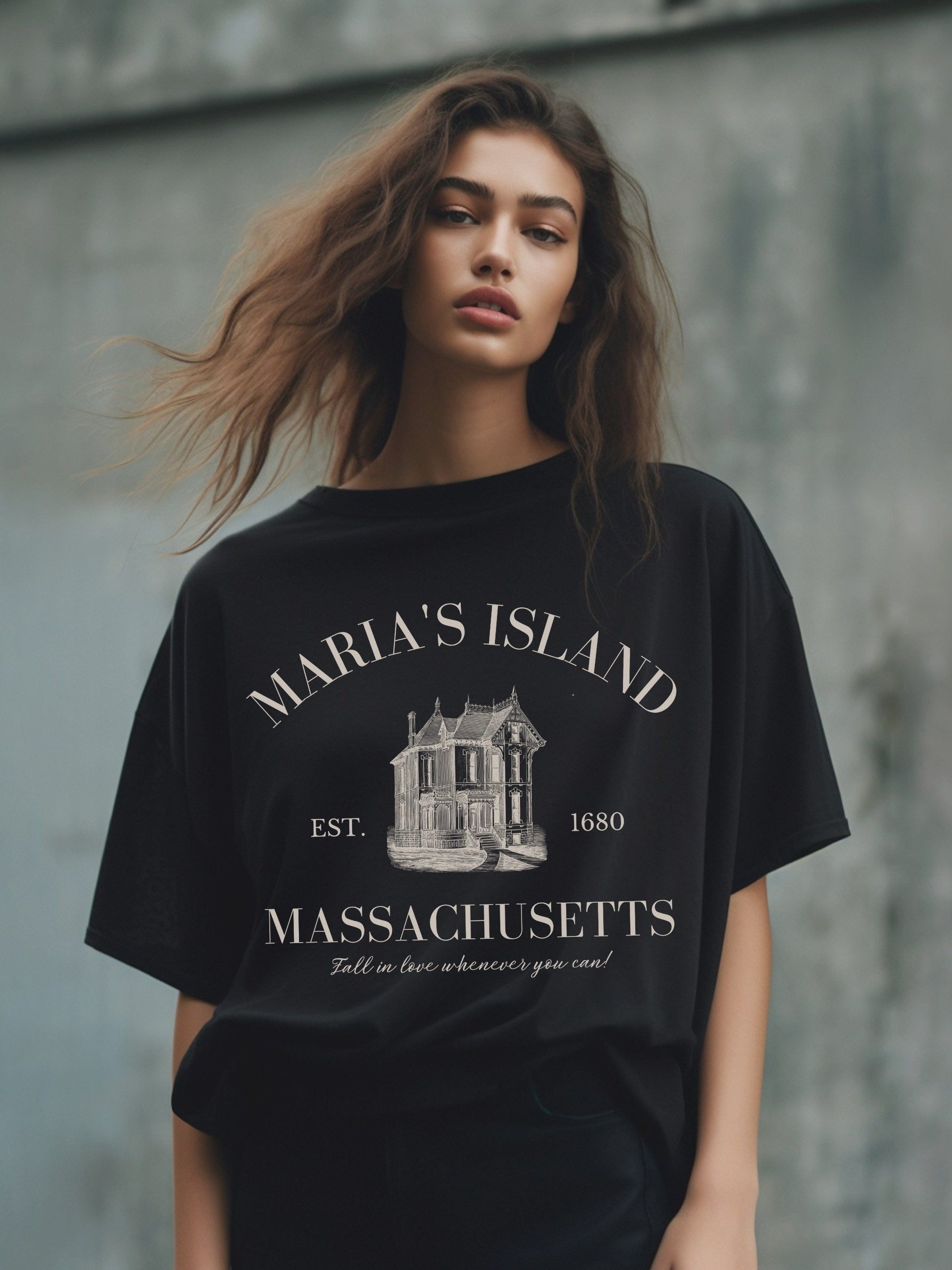 Woman wearing an oversized tshirt in black, designed to look like a vintage souvenir tee with the text &quot;Maria&#39;s Island, Massachusetts, est. 1680. Fall in love whenever you can!&quot; Perfect for Practical Magic fans!